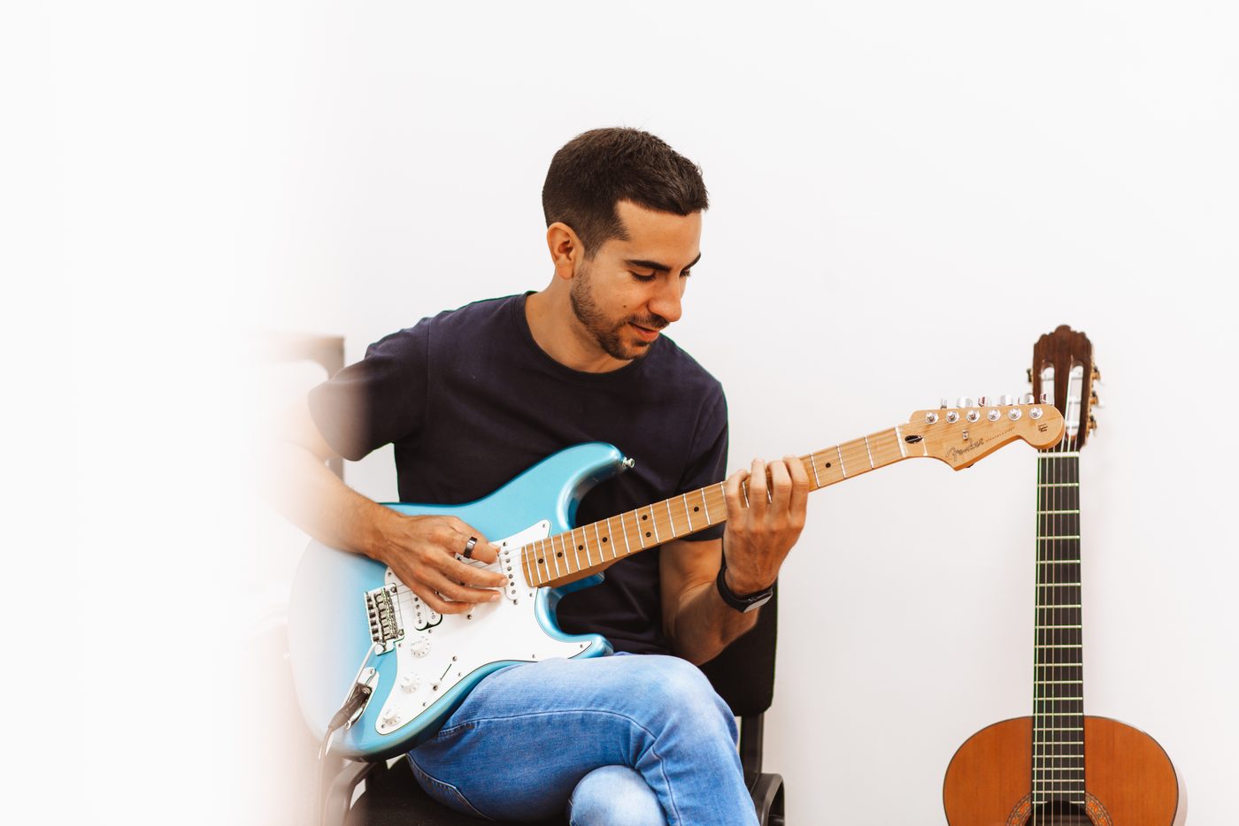 Jorge Fernández, profesor de guitarra, tocando una Fender Stratocaster en su academia